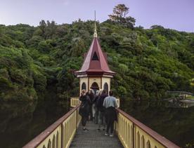 People gather on the bridge to the water tower in the middle of the reservoir at Zealandia. 