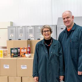 2 people standing next to their product, the Upcycled Grain Project.