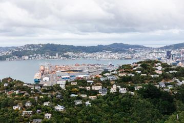 Wellington harbour and city surrounded by green hills.