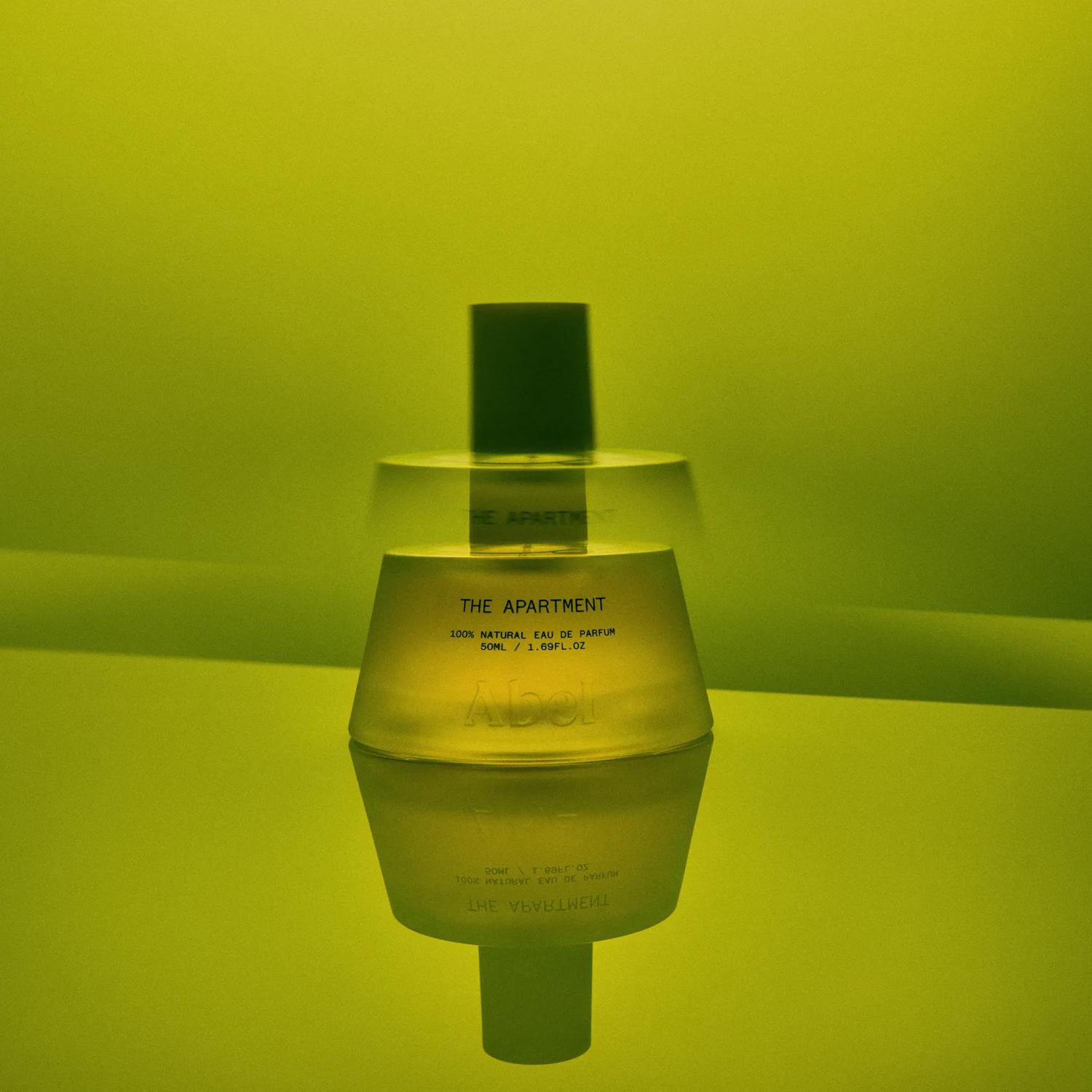 The Apartment fragrance bottle from Abel on a green background.