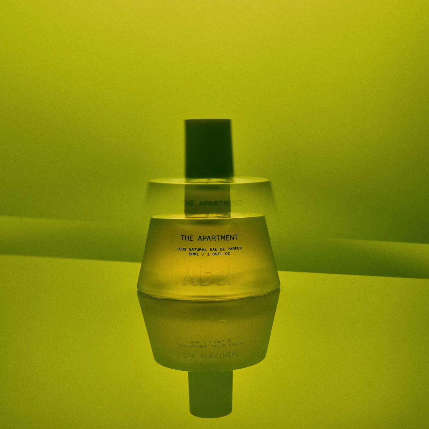 The Apartment fragrance bottle from Abel on a green background.