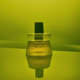 The Apartment fragrance bottle from Abel on a green background.