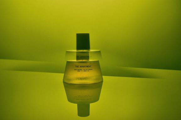 The Apartment fragrance bottle from Abel on a green background.