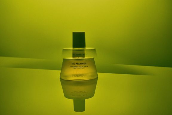 The Apartment fragrance bottle from Abel on a green background.