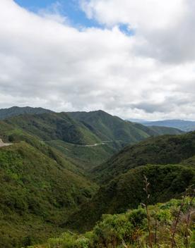 The screen location of Remutaka Summit, wit views of surrounding peaks, lush green bush and steep roads cut into the sides of the mountains.