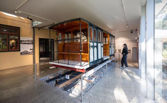 A person looks at a life-size model of an old cable car at the Cable Car Museum in Kelbunr, Wellington.