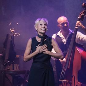 Singer, Nathalie Lermitte, performs her tribute show 'Piaf! The Show" on stage with a double bass accompaniment.