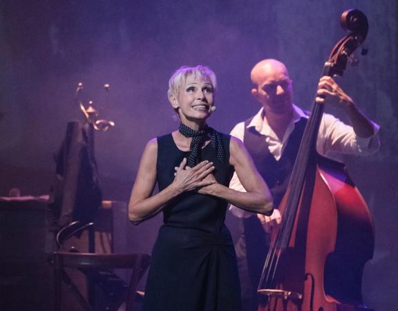 Singer, Nathalie Lermitte, performs her tribute show 'Piaf! The Show" on stage with a double bass accompaniment.