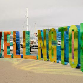 The Well_ngton Sign on Wellington's waterfront is reskinned in a reflective colourful material.