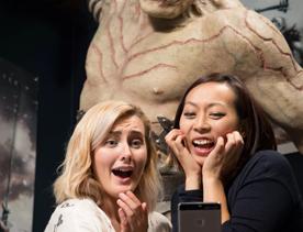 Two people take a selfie with a statue of an orc, an aggressive and ugly race of monsters from the Lord of the Rings at Wētā Cave and Workshop.