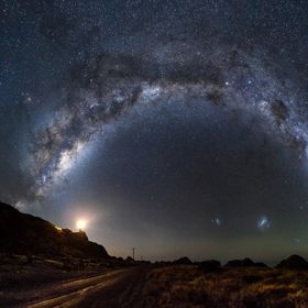 A panorama of the Milky Way high in the sky, stretching from east to west. Shot at a Wairarapa Dark Sky reserve location at Cape Palliser on the bottom of the North Island of New Zealand.