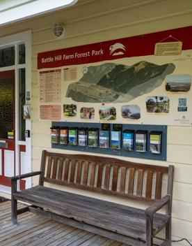 A wooden bench seat outside the Battle Hill Farm homestead, with brochures.