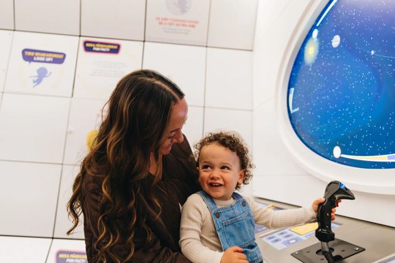 A mother and child play in the spaceship control room at Space Place in Wellington.