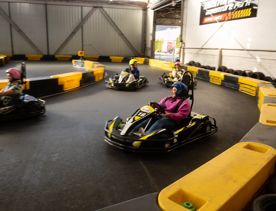 Four people racing in go karts at Daytona indoor raceway at Brewtown