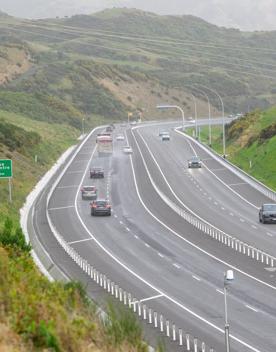 The 4 lane motorway of Transmission Gully, surrounded by green hills.