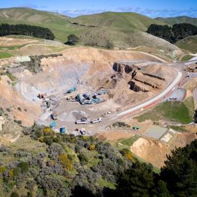 An aerial view of the Willowbank Quarry with work trucks and heavy machinery under a sunny blue sky.