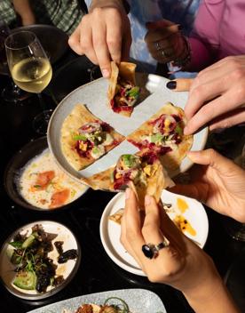 Plates of food are being passed around from hand to hand.
