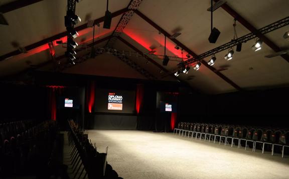 The interior of Pipitea Marae & Function Centre located in Pipitea, Wellington. The space is dark, with red accent lighting setup for a runway. 