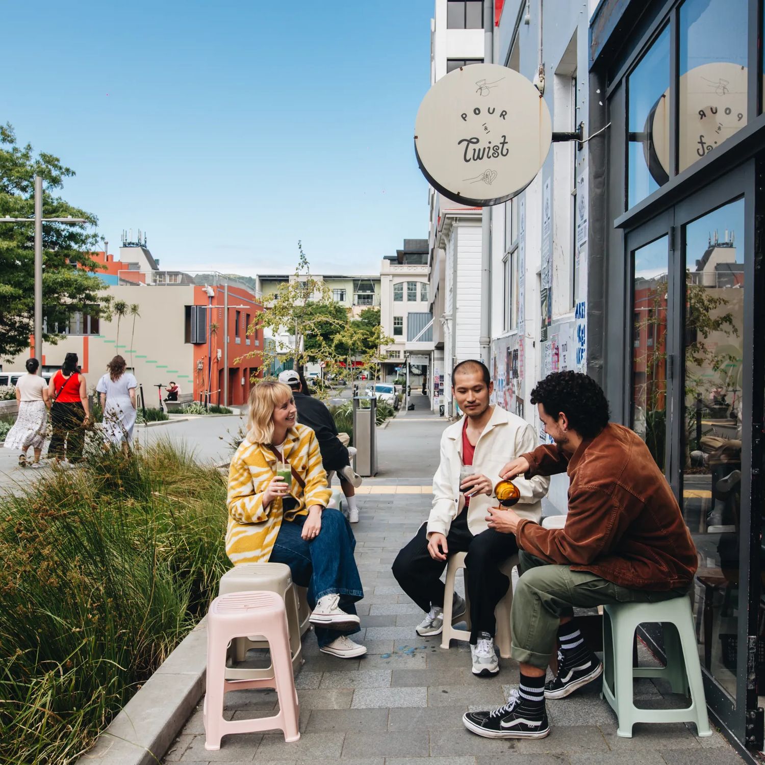 Three friends enjoy coffee outside of Pour & Twist.
