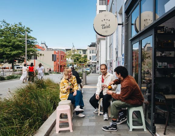 Three friends enjoy coffee outside of Pour & Twist.