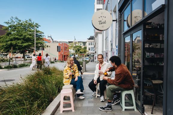 Three friends enjoy coffee outside of Pour & Twist.