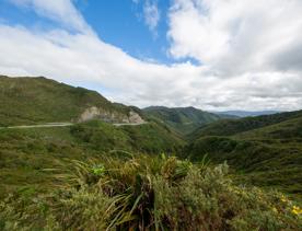 The screen location of Remutaka Summit, wit views of surrounding peaks, lush green bush and steep roads cut into the sides of the mountains.