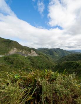The screen location of Remutaka Summit, wit views of surrounding peaks, lush green bush and steep roads cut into the sides of the mountains.