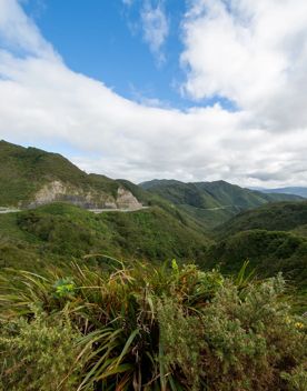The screen location of Remutaka Summit, wit views of surrounding peaks, lush green bush and steep roads cut into the sides of the mountains.