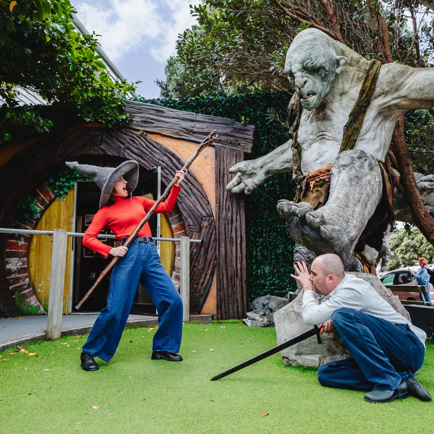 Two friends act out a battle scene with an orc statue at Wēta Workshops in Miramar, Wellington.