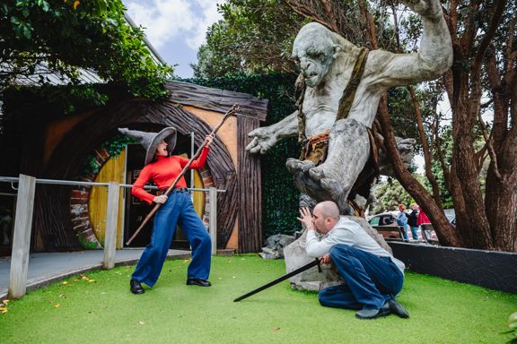 Two friends act out a battle scene with an orc statue at Wēta Workshops in Miramar, Wellington.