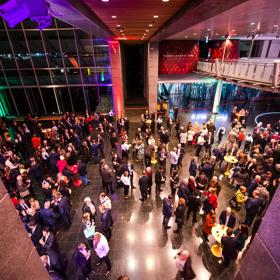 The foyer room at the Museum of New Zealand Te Papa Tongarewa during a event. The space is full of people in semi-formal wear.