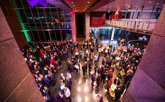 The foyer room at the Museum of New Zealand Te Papa Tongarewa during a event. The space is full of people in semi-formal wear.