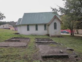 The screen location of Whiitemans Valley, nestled among trees and hills, old buildings have been built to mimic an old town.