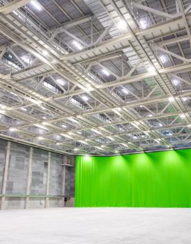 Inside a large building at Lane Street Studios, with a very large green curtain on one end.