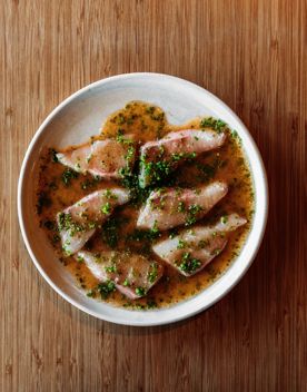 A close-up of a dish at Koji, the kingfish sashimi with truffle yuzu, and chives.