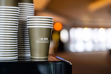 Three stacks of compostable takeaway coffee cups.