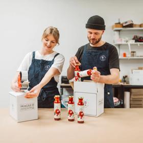 Lydia Harfield and Mat Watkins, co-founders of Apostle Hot Sauce, bottle and package their product from their kitchen.