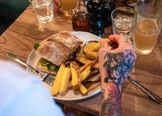 A plate of thick cut fries and a sandwich.