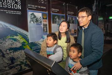 A family of four looks at an interactive display at Space Place.