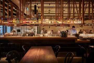 Looking into the bar at Astoria as people work and customers dine in the background.