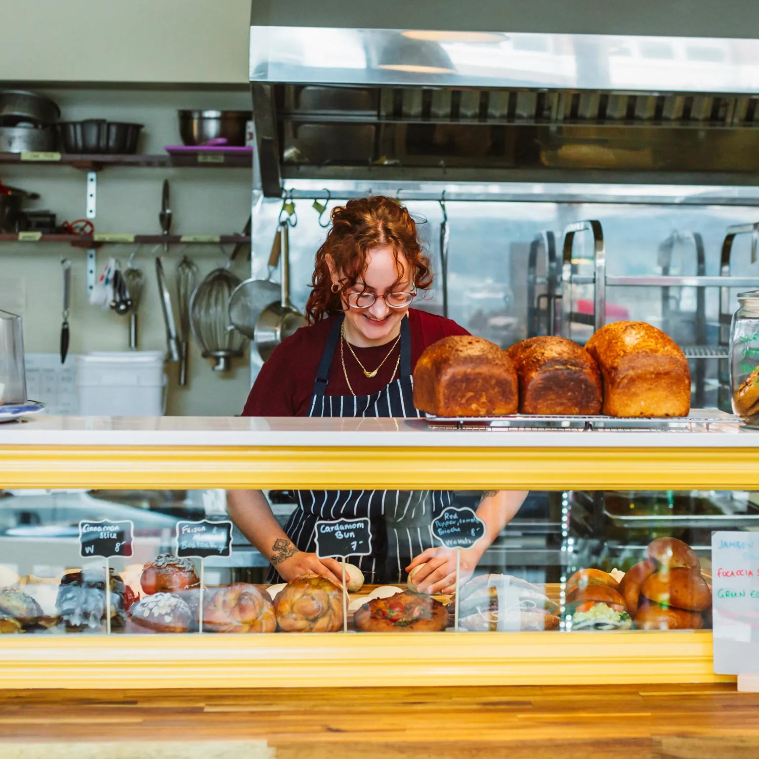 A pastry chef rolls dough behind the counter at Amuse Snack Bar.