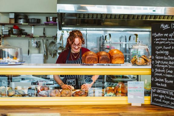 A pastry chef rolls dough behind the counter at Amuse Snack Bar.