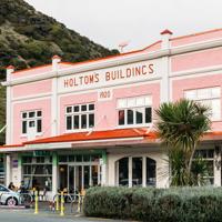 An exterior shot of the Holtoms art gallery in paekākāriki, a gorgeous old pink building with orange trim.