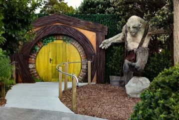 A recreation of a hobbit home with a circular door and an orc from Lord of the RIngs.