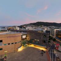 Drone image of Te Papa and Tākina at sunset, with view of Wellington harbour, Mount Victoria and city in background.