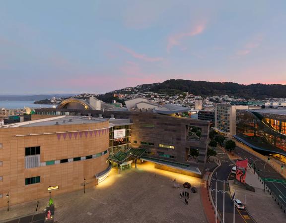 Drone image of Te Papa and Tākina at sunset, with view of Wellington harbour, Mount Victoria and city in background.