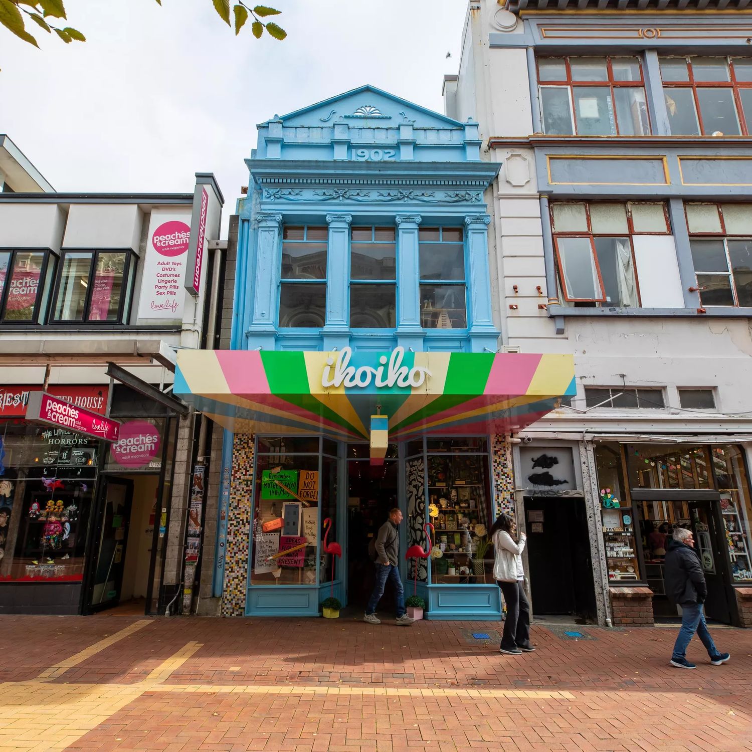The beautiful blue exterior of Iko Iko contrasted to the grey of the buildings beside it on Cuba street.