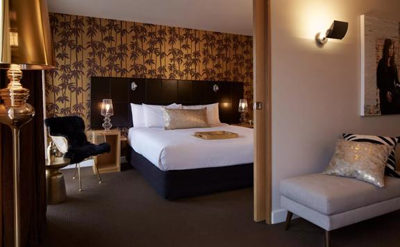 Inside a chic room at the Museum Apartment Hotel in Te Aro, Wellington. The decor is neutral tones of grey and beige with gold accents. 