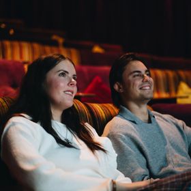 A couple watches a film in a cinema.