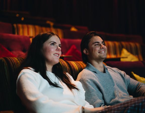 A couple watches a film in a cinema.